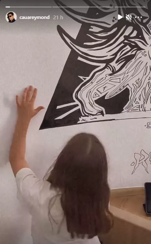 Cauã Reymond mostrando a filha realizando uma pintura
