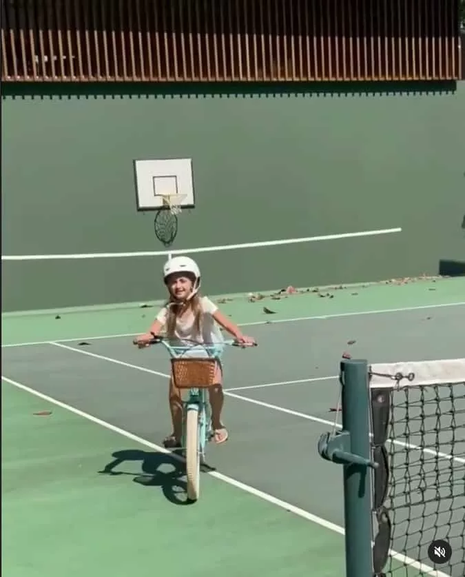 Angélica mostrando sua filha na quadra de tênis da mansão