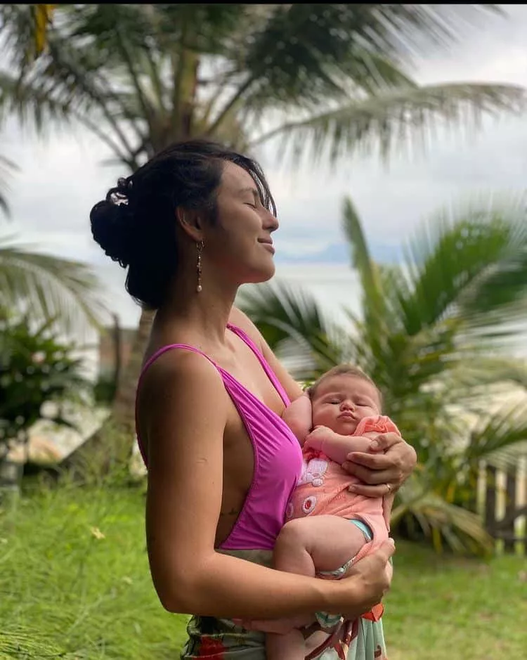Yanna Lavigne posa com a bebê nos braços na praia