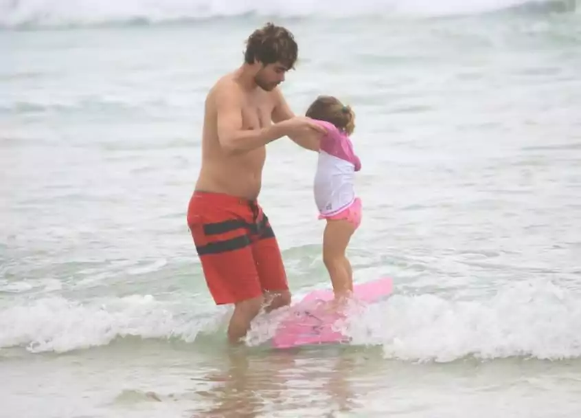 Rafael Vitti surge surfando com a filha em praia no Rio de Janeiro 