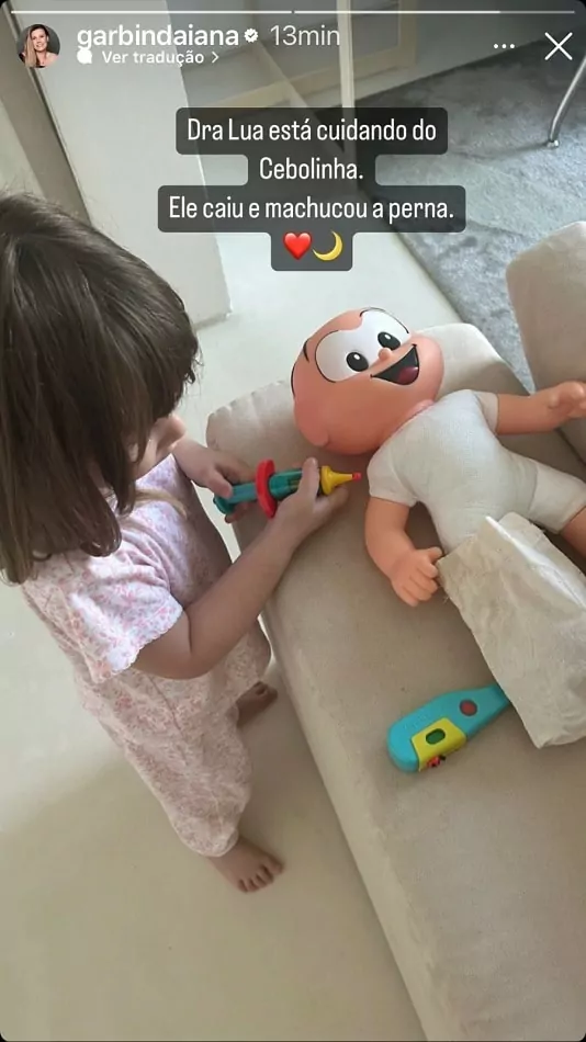 Lua, filha de Daiana Garbin e Tiago Leifert, brincando com seu boneco