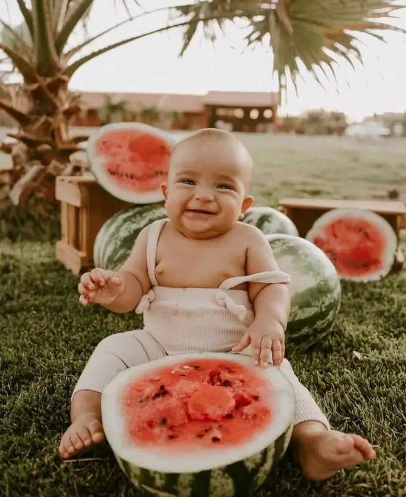 Jorge, filho de Ary Mirelle e João Gomes, em um ensaio de fotos com melancias