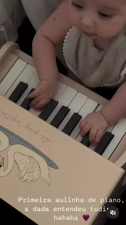 Rafaella Santos mostrando a bebê Helena em sua aula de piano