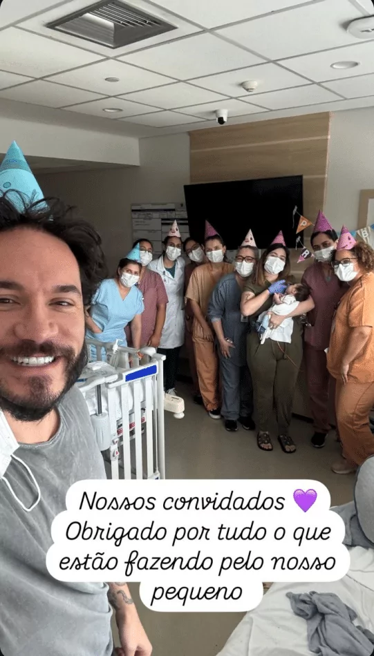 Eliezer e Viih posam com o bebê e a equipe do hospital na festa